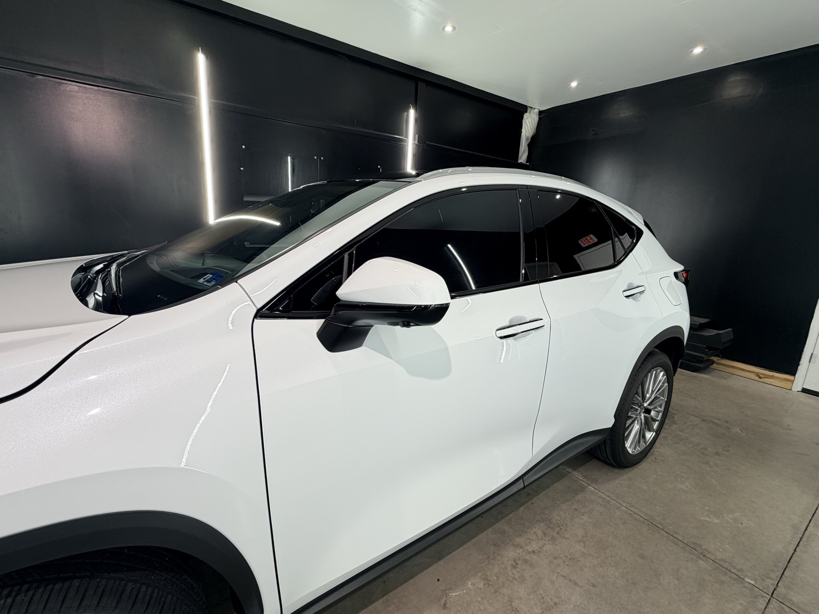 White Lexus NX with tinted windows in the bay